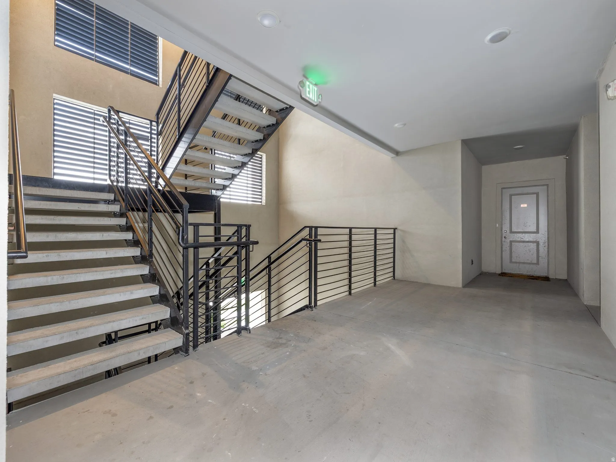 Industrial-style staircase featuring metal railings and concrete treads