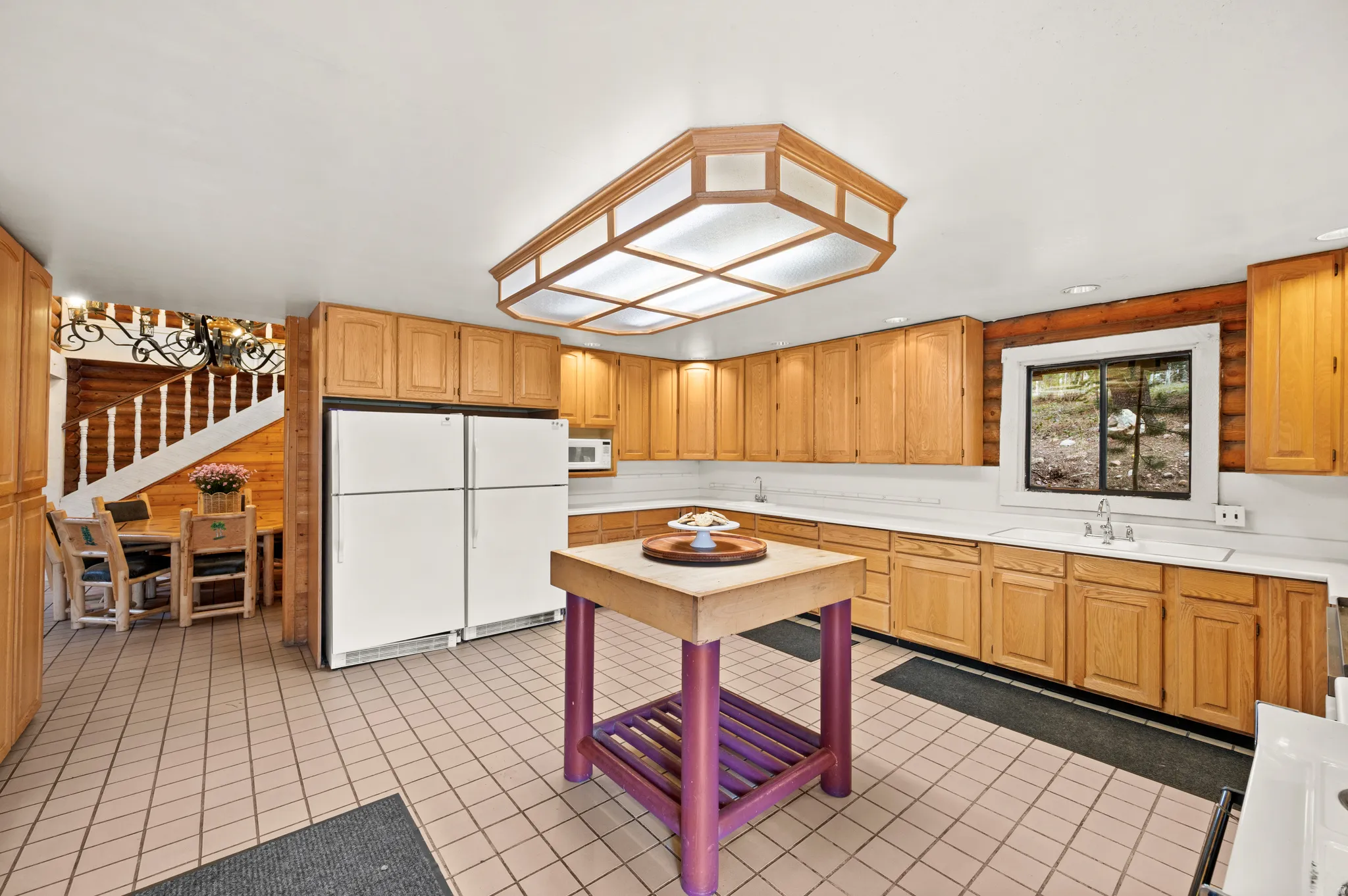 Spacious kitchen featuring extensive wood cabinetry, light-toned countertops, and a central island