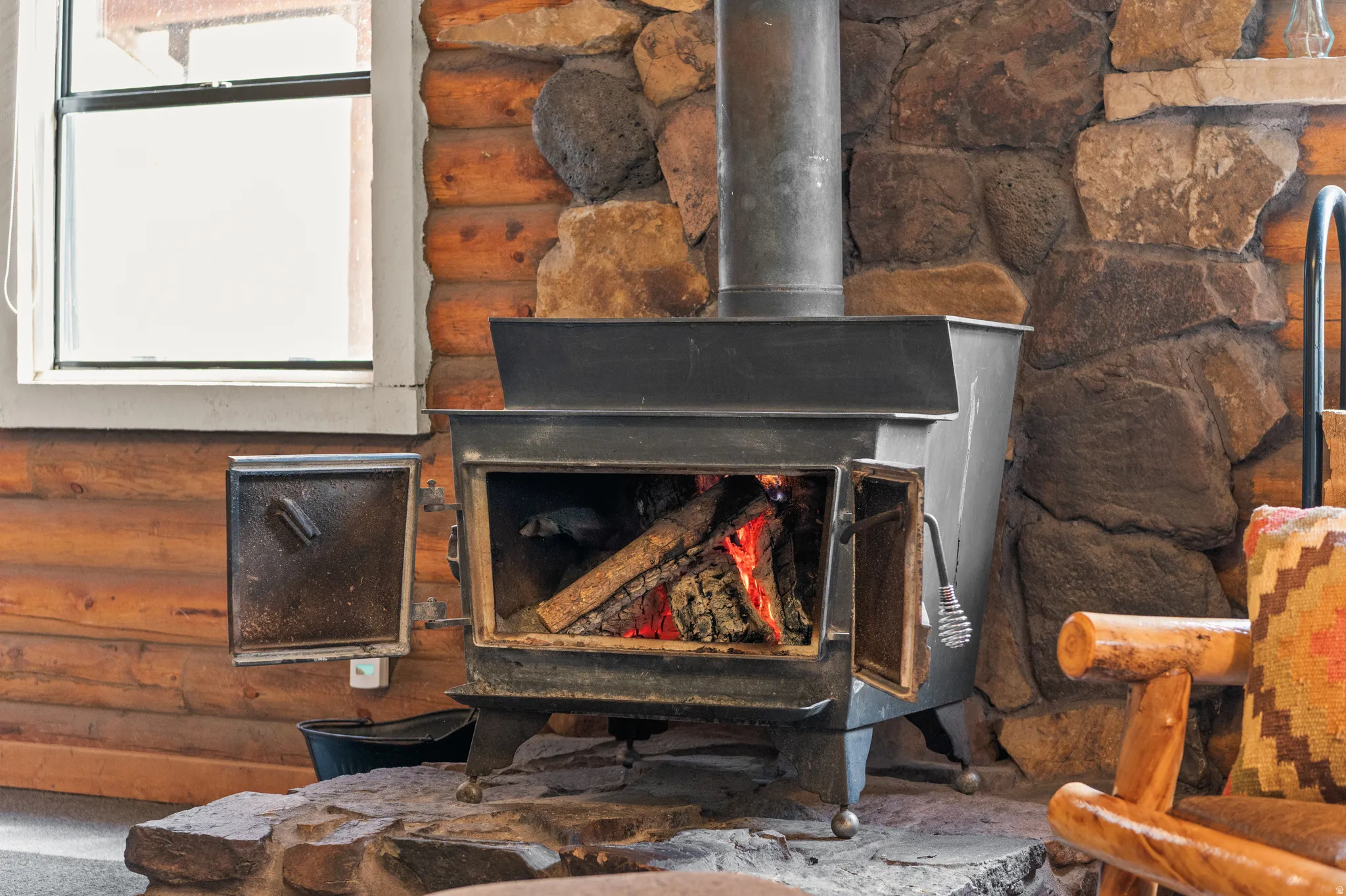 Cast iron wood-burning stove with a stone hearth