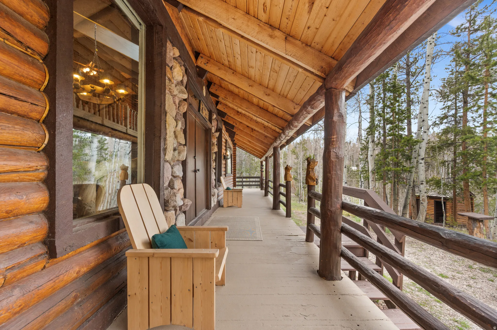 Expansive wood-finish porch featuring a log construction exterior with stone accents