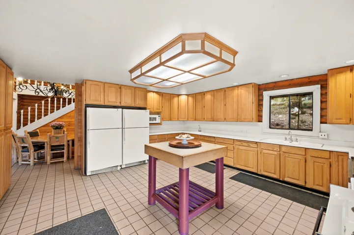 Spacious kitchen featuring extensive wood cabinetry, light-toned countertops, and a central island