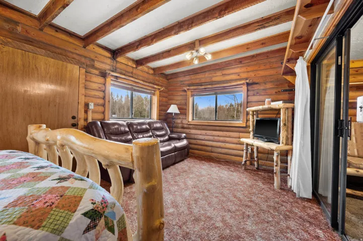 Rustic interior featuring natural wood log walls and exposed beam ceilings