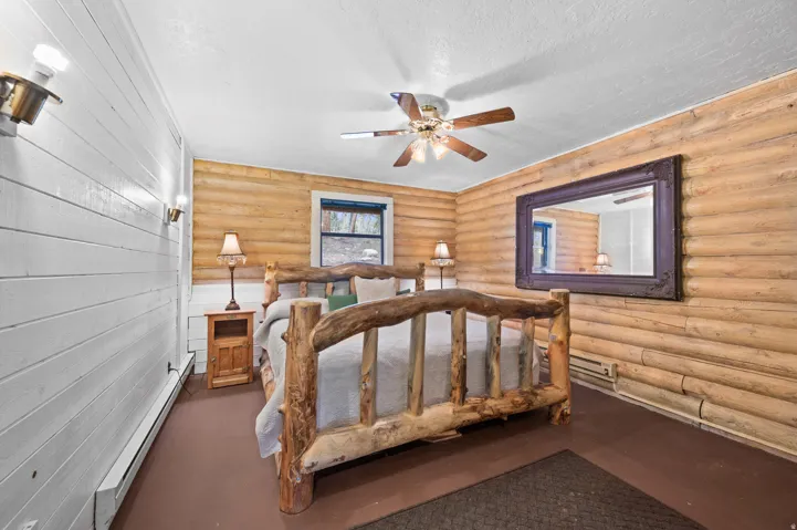 Interior room featuring a wood-finish bed frame, wood-paneled walls, and a white plank wall