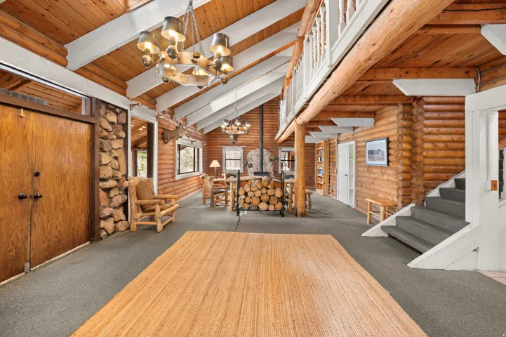 Open concept interior with exposed wood beams and log walls