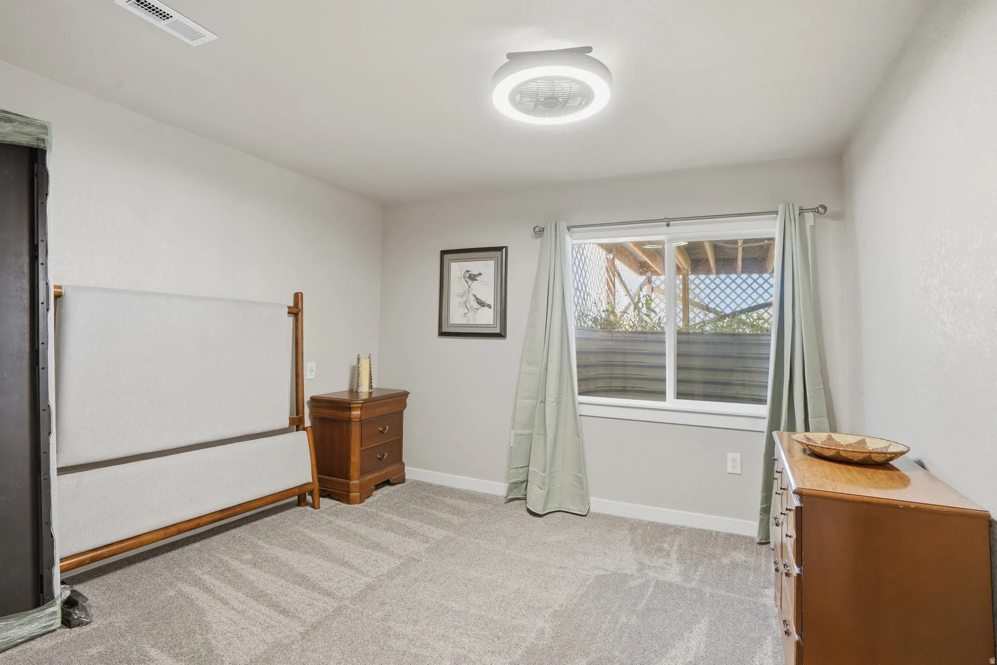 Carpeted interior space featuring a double-hung window, a ceiling-mounted light fixture, and light-toned wall paint