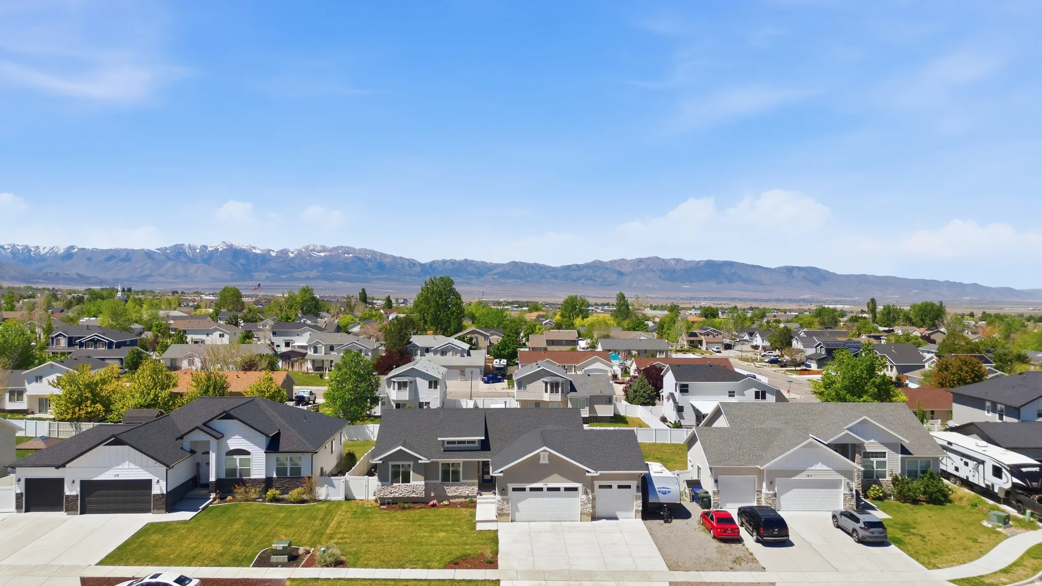 Residential neighborhood with established homes and mature trees, set against a backdrop of distant mountains