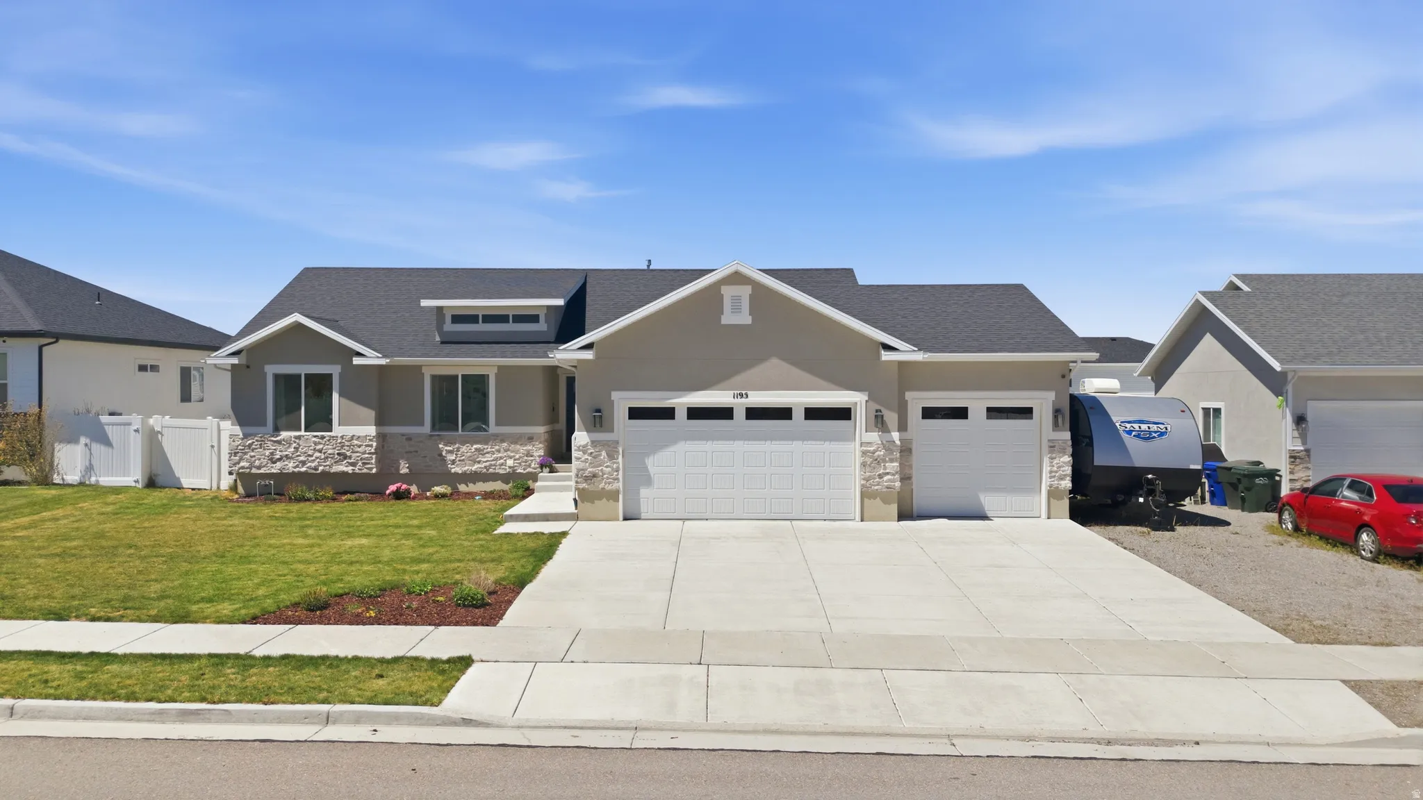 Ranch-style residence featuring a stucco exterior with stone accents and a dark shingle roof with space for RV