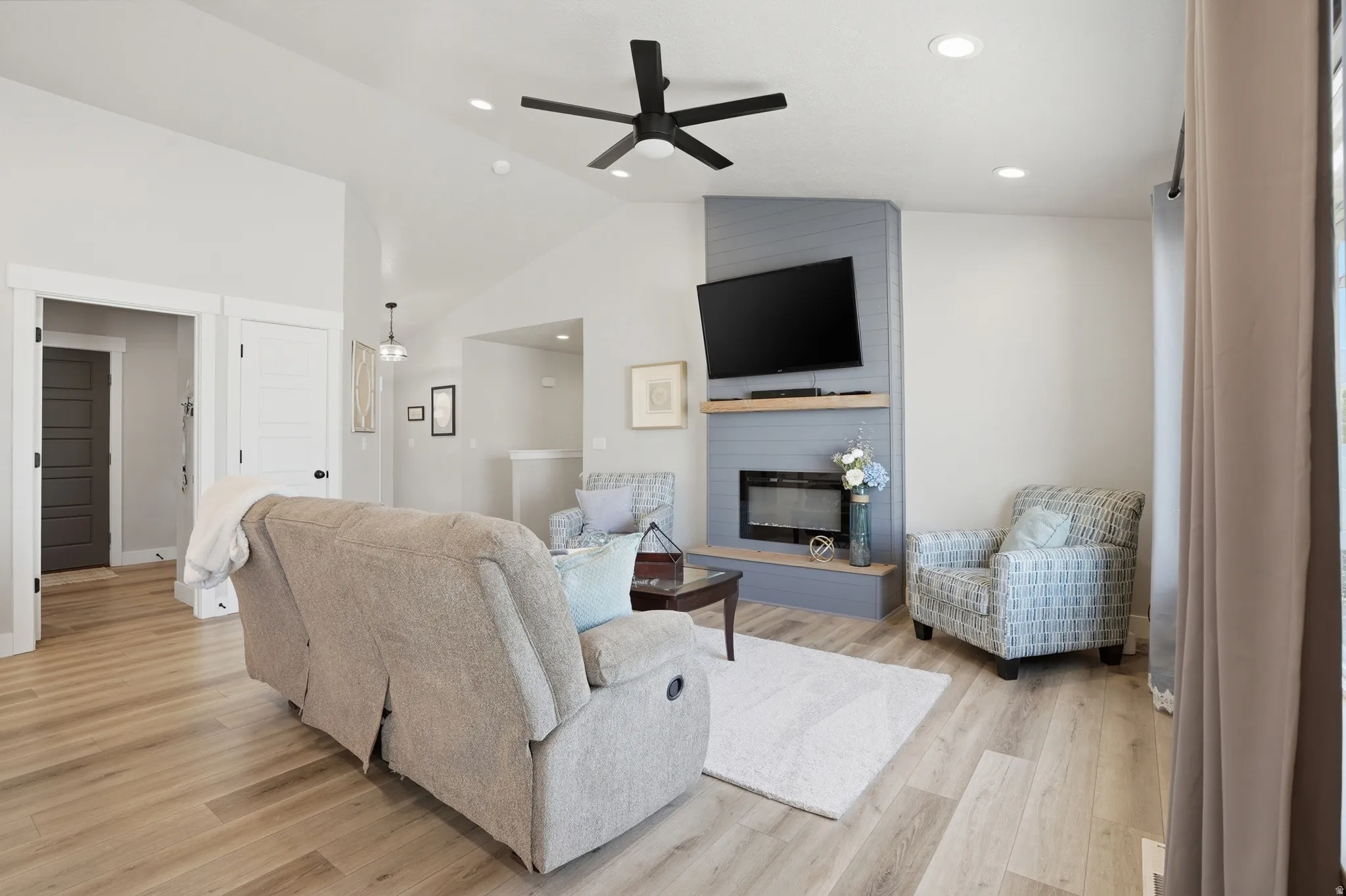 Living space featuring vaulted ceilings, fireplace, and recessed lighting