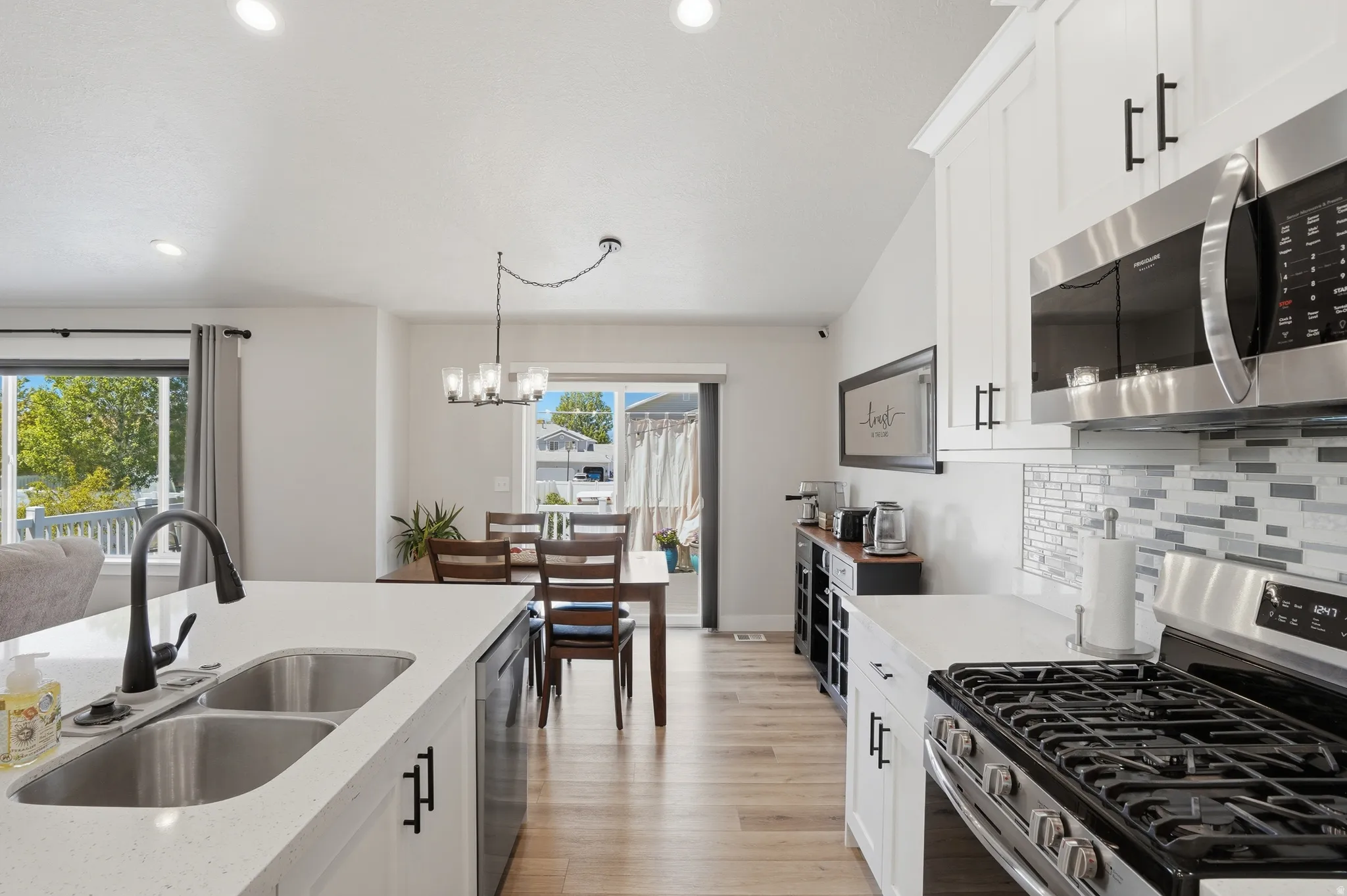 Contemporary kitchen with white cabinetry and stainless steel appliances