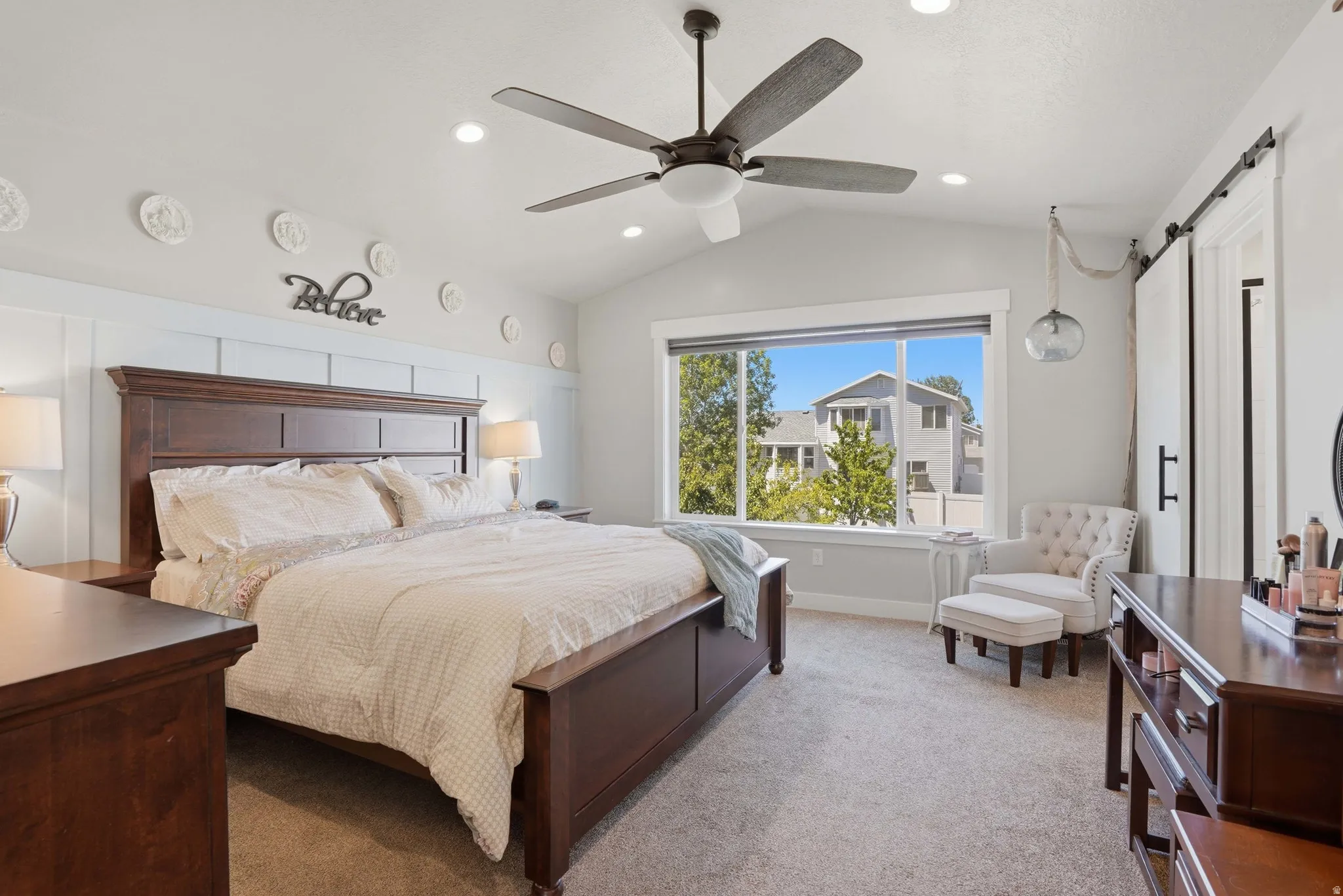 Primary bedroom featuring vaulted ceilings, recessed lighting, a modern ceiling fan, and a large window