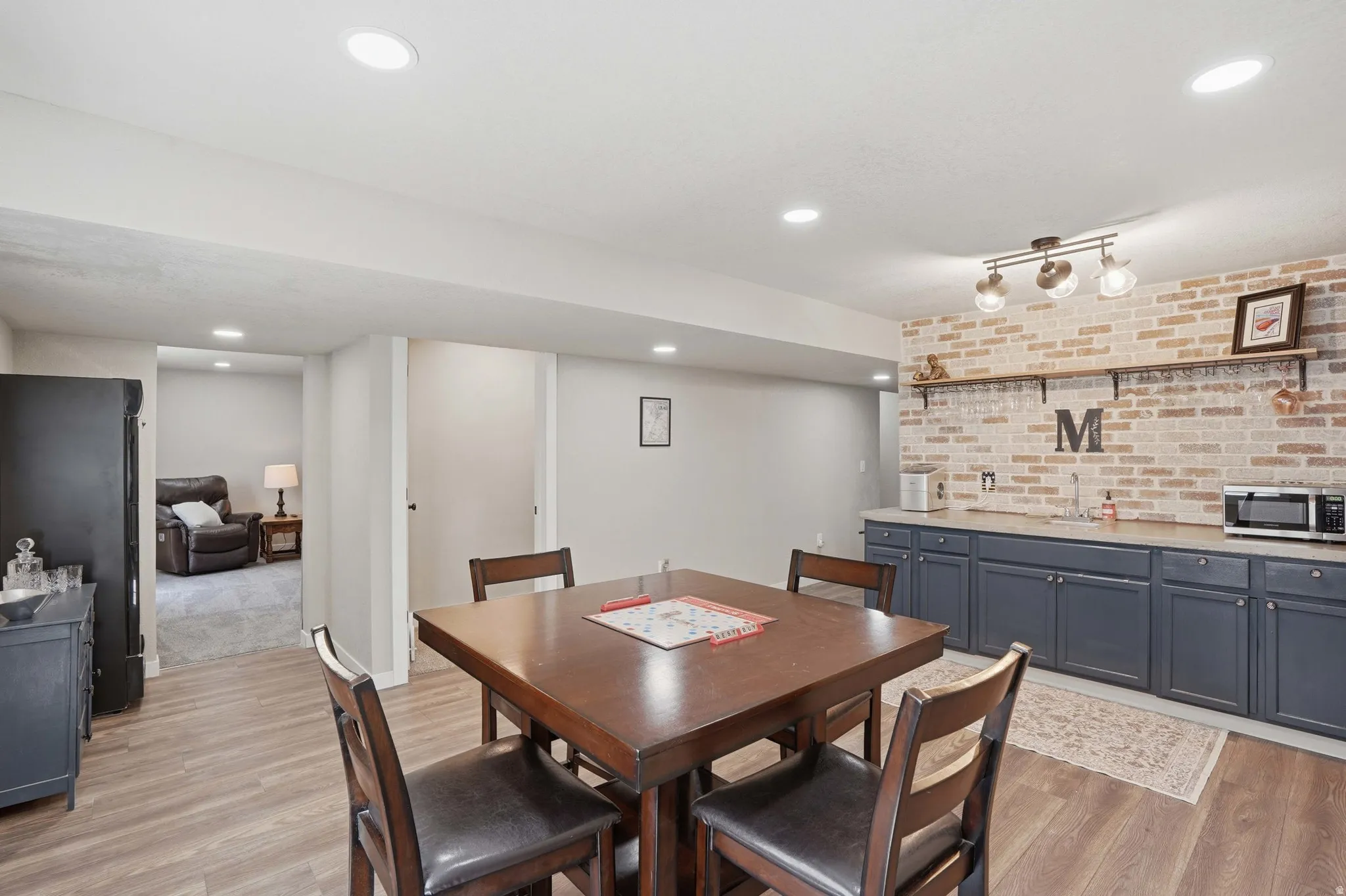 Dining area with  with brick wall, wood-finish flooring and recessed lighting