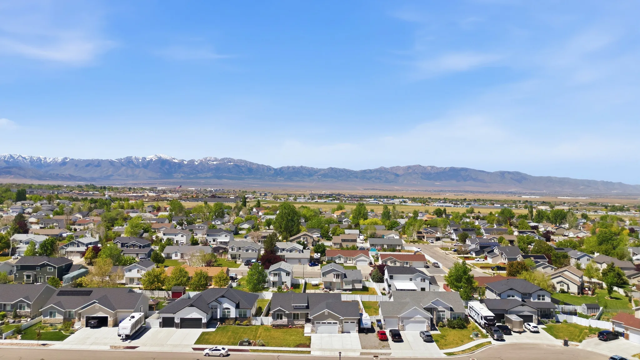 Expansive neighborhood featuring residential properties, paved streets and distant mountain ranges