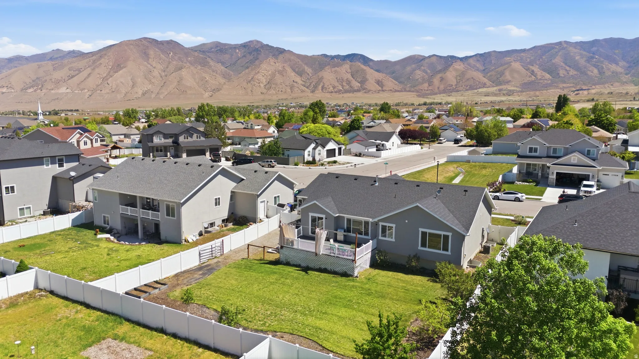 Aerial perspective of a residential property featuring a gray exterior and dark shingle roof