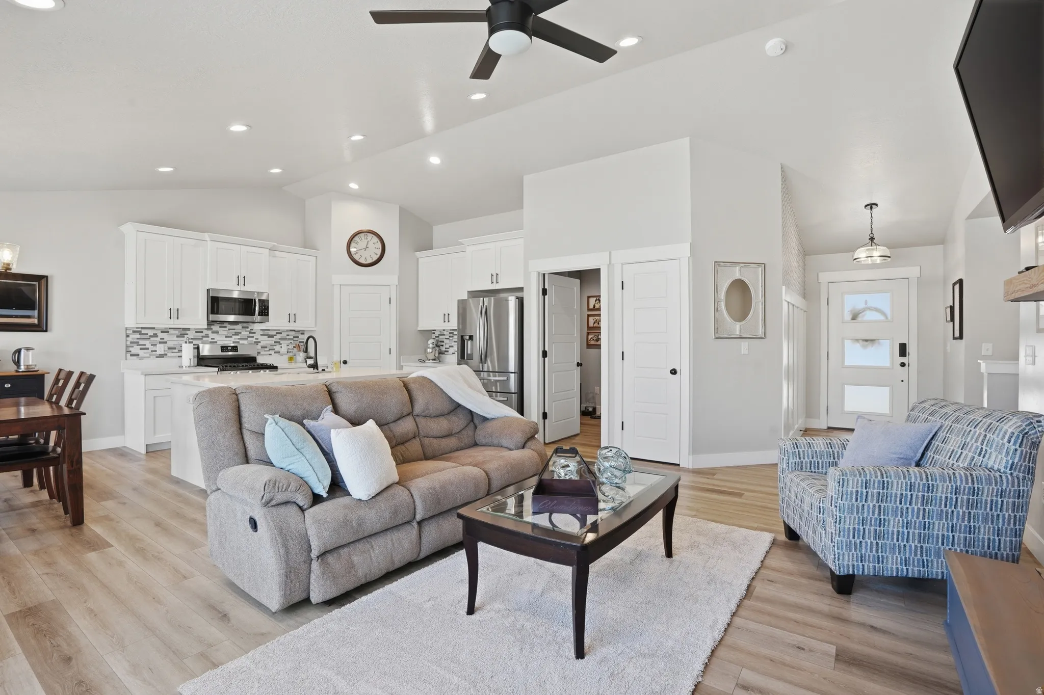 Open-concept living space featuring wood-finish flooring, recessed lighting, and a ceiling fan
