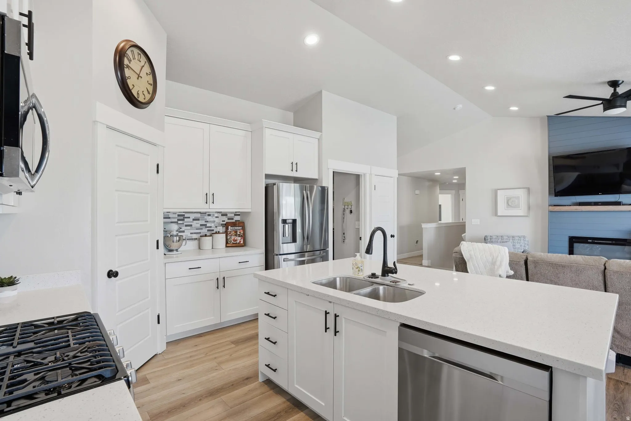 Bright kitchen featuring a central island with an undermount sink and stainless steel dishwasher