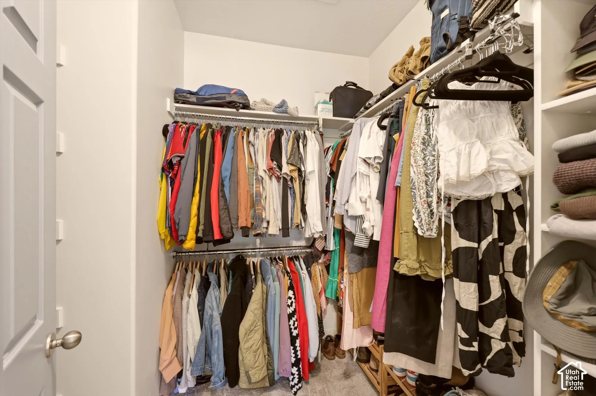 Walk-in closet featuring floor-to-ceiling custom shelving, multiple clothing rods, and built-in storage cubbies
