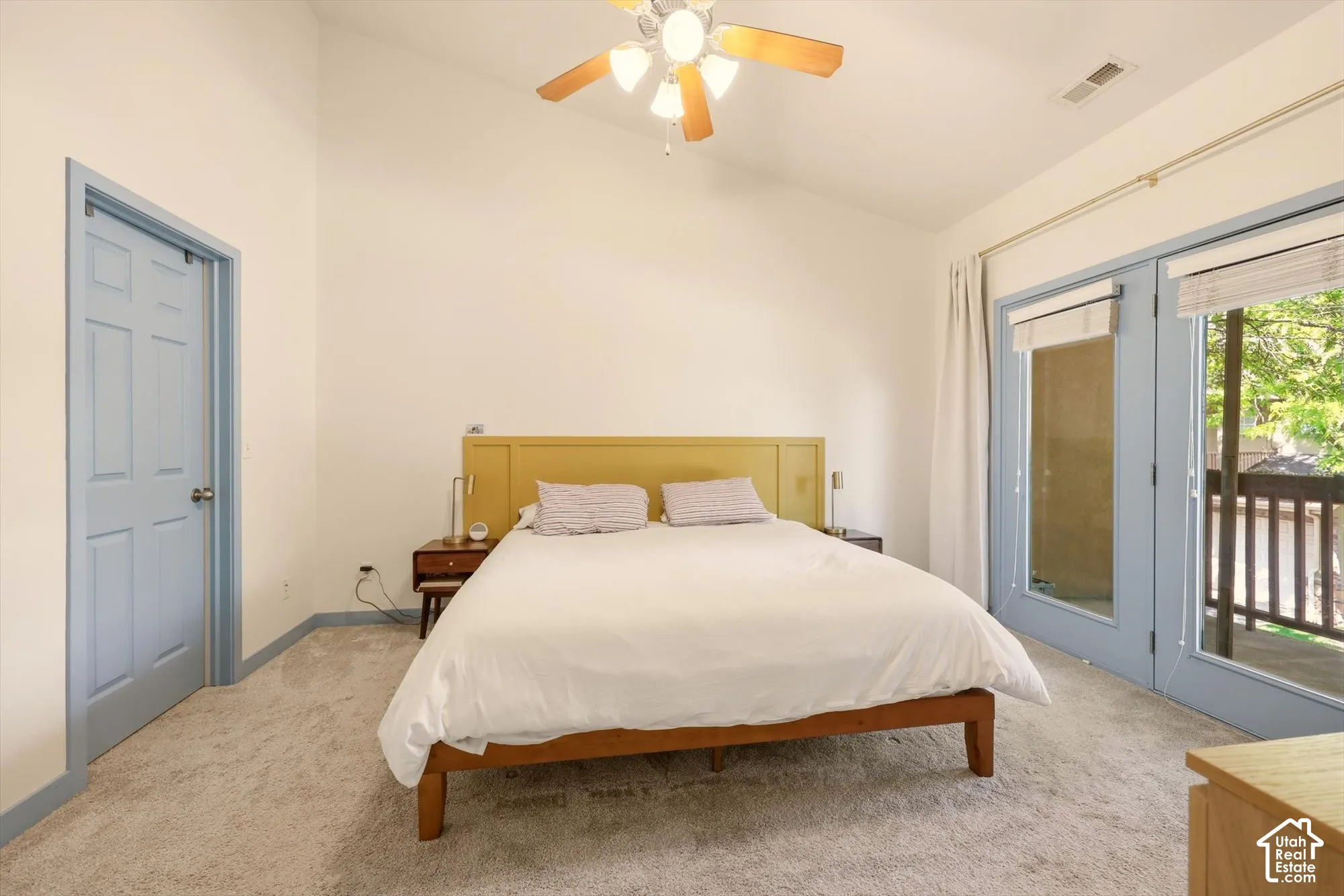 Carpeted room with a vaulted ceiling and a ceiling fan