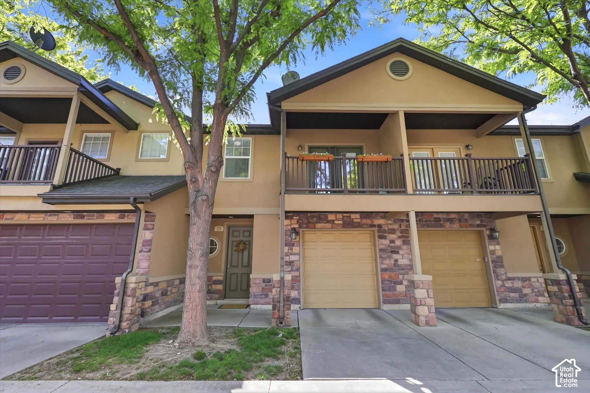Townhome exterior featuring stucco siding and stone veneer accents