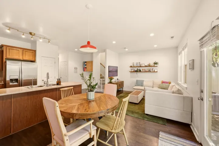 Open-concept living area featuring wood-finish flooring, recessed lighting, and white walls