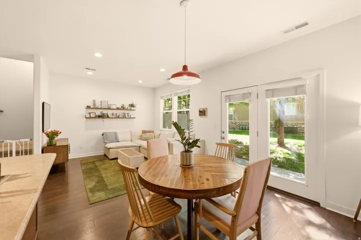 Open-concept living area featuring rich wood-finish flooring, recessed lighting, and a red pendant light fixture