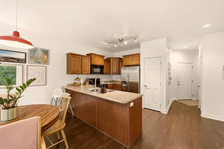 Kitchen featuring wood-finish cabinetry, stainless steel appliances, and a peninsula with countertop seating