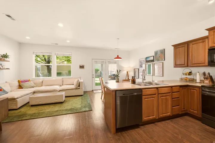 Open-concept living space featuring wood-finish flooring, recessed lighting, and ample natural light from multiple windows