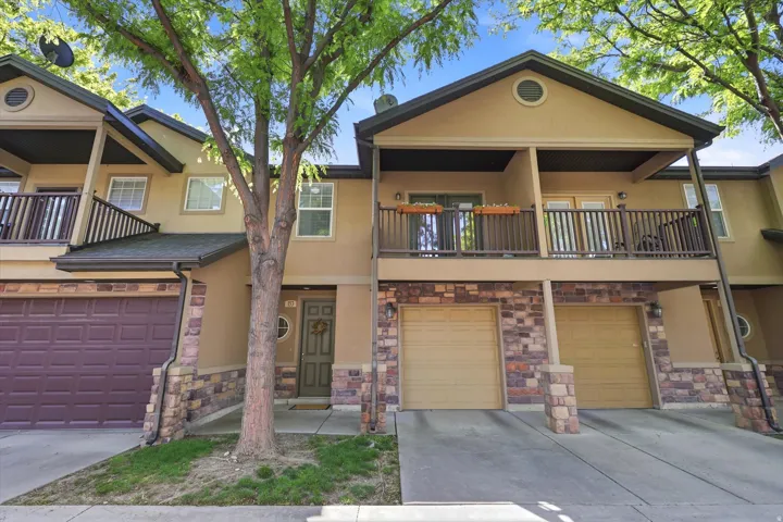 Townhome exterior featuring stucco siding and stone veneer accents