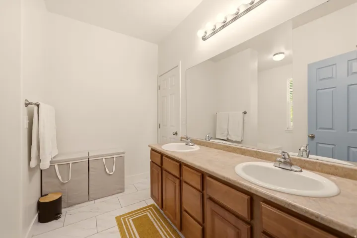 Double vanity with laminate countertops, two undermount sinks, and chrome faucets