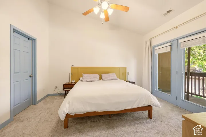Carpeted room with a vaulted ceiling and a ceiling fan