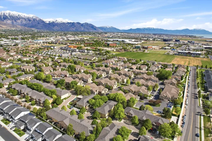 Expansive residential community with diverse housing styles, established landscaping, and distant mountain ranges