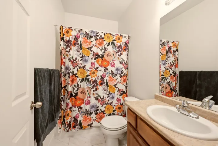 Bathroom featuring a light-toned vanity with an integrated sink, a chrome-finish faucet, and a large mirror