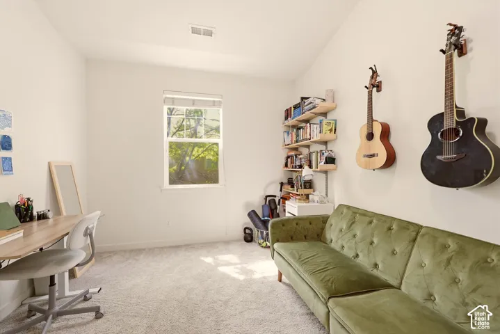 Bright room with light-colored carpeting, a single window, and a vaulted ceiling
