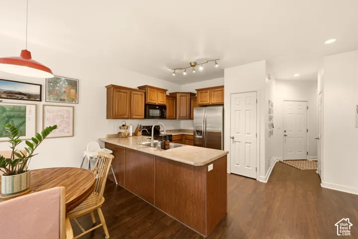 Kitchen featuring wood-finish cabinetry, stainless steel appliances, and a peninsula with countertop seating