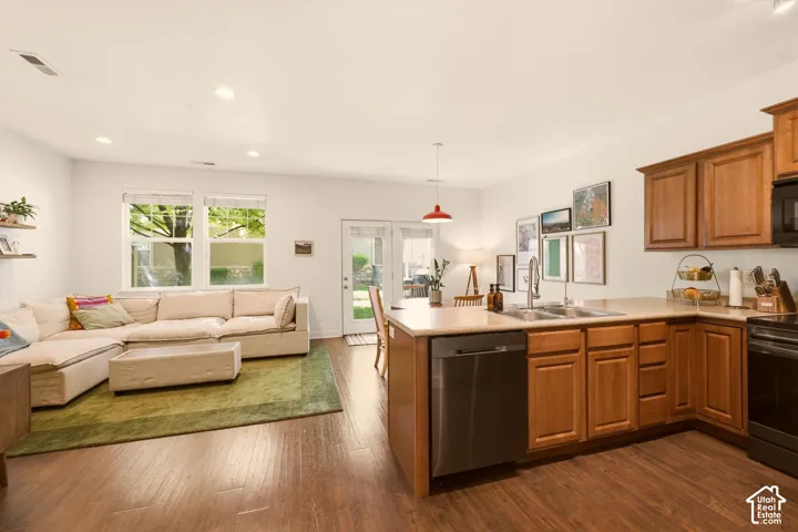 Open-concept living space featuring wood-finish flooring, recessed lighting, and ample natural light from multiple windows