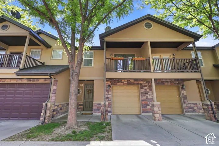 Townhome exterior featuring stucco siding and stone veneer accents