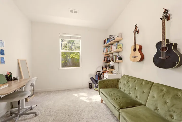 Bright room with light-colored carpeting, a single window, and a vaulted ceiling