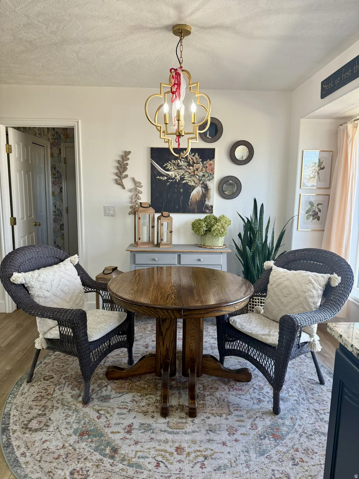 Dining area featuring a gold-finish chandelier, a built-in window seat, and wood-finish flooring