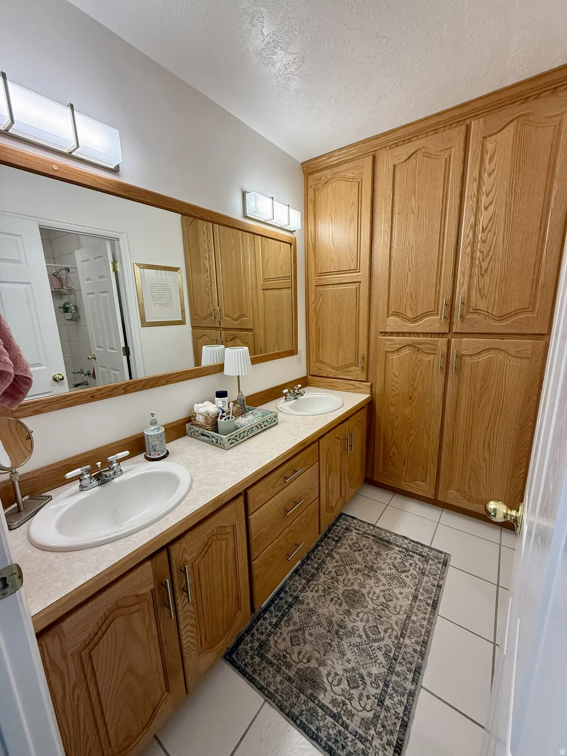 Dual vanity with integrated white sinks and chrome fixtures, set in a light-toned countertop