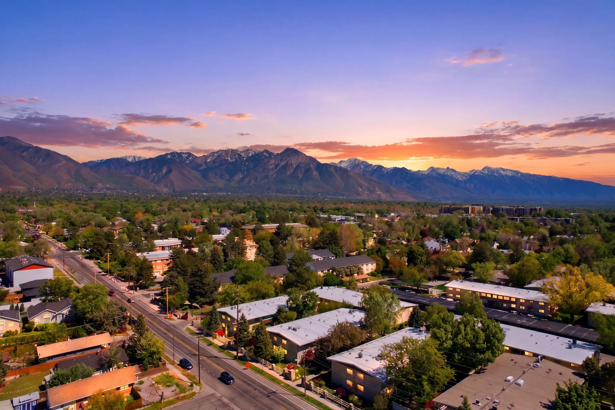 Mountain range backdrop with a vibrant sunset and extensive tree coverage