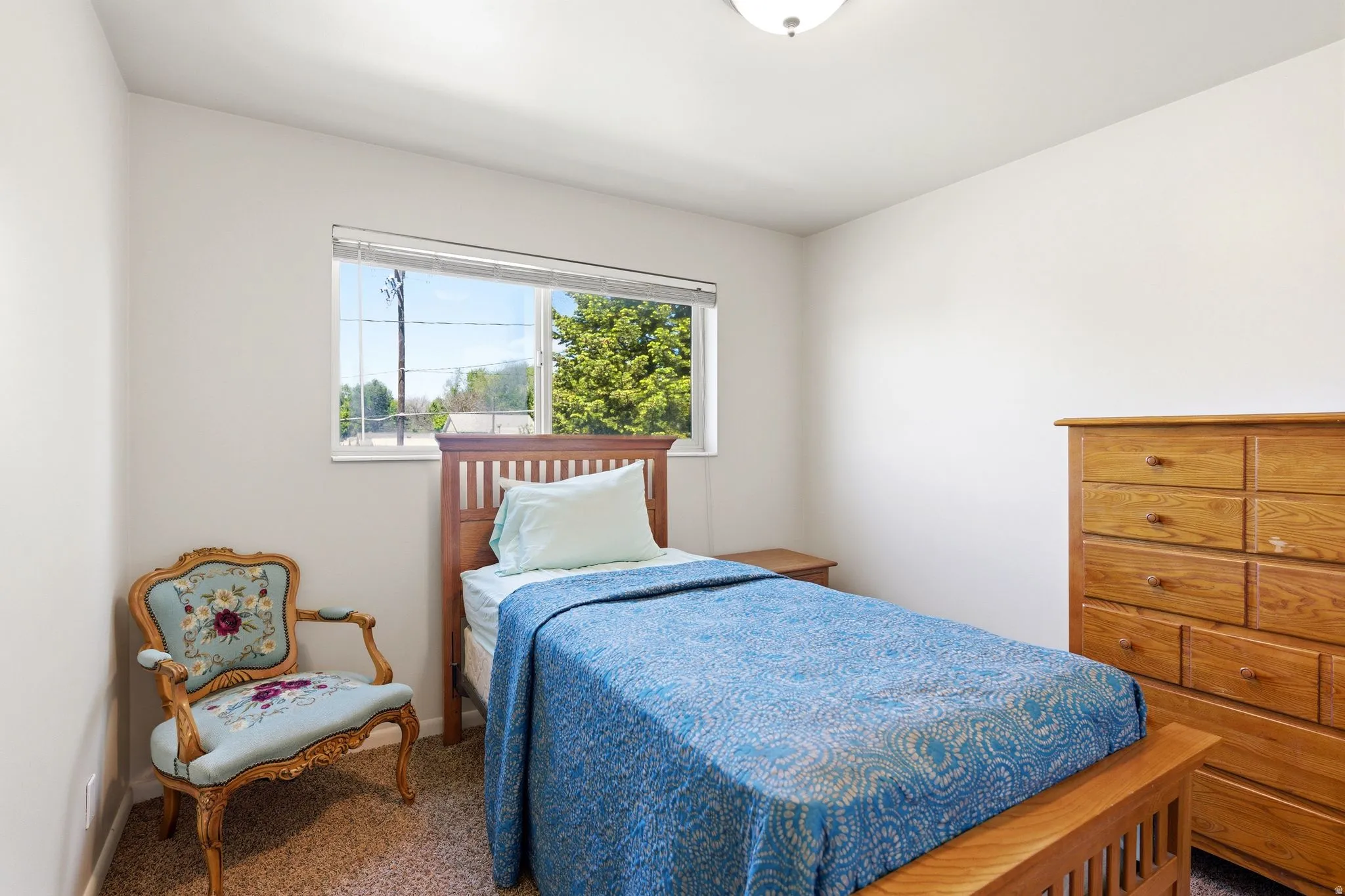 Bedroom featuring a single window with blinds, a ceiling-mounted light fixture, and light-toned walls