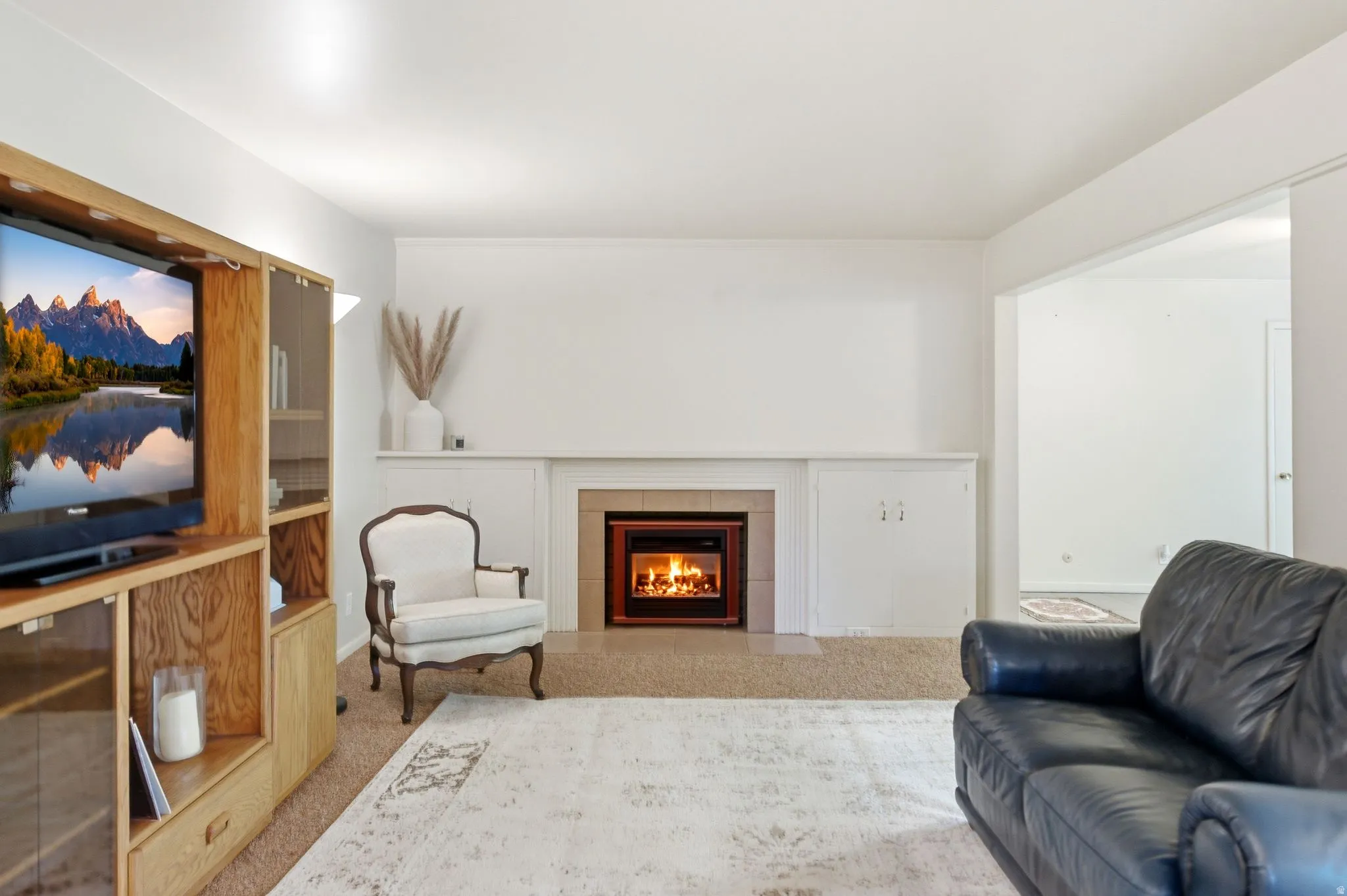 Living area featuring a fireplace with a light-colored tile surround and a white mantel