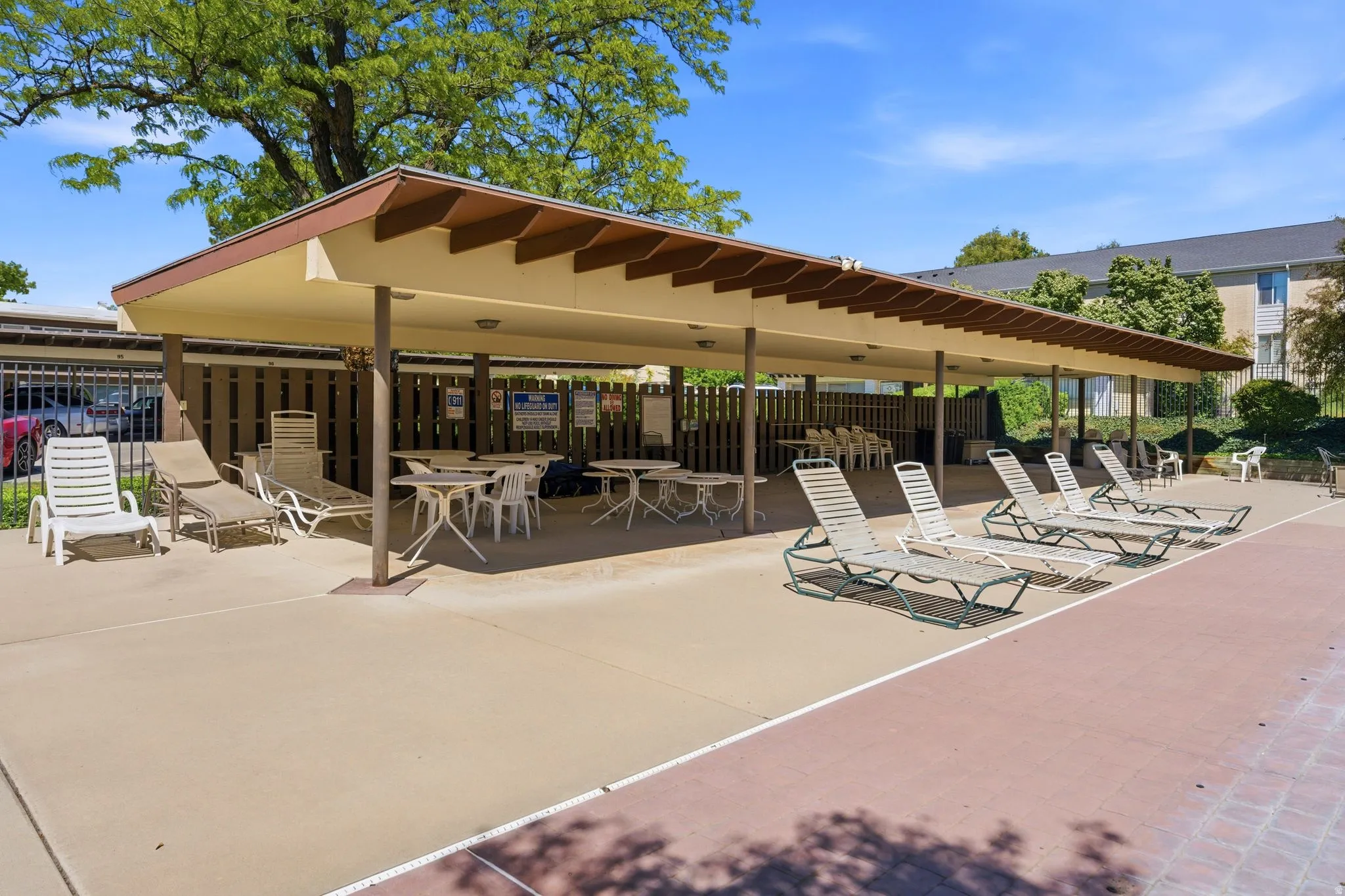 Covered patio area with concrete flooring, supported by multiple columns