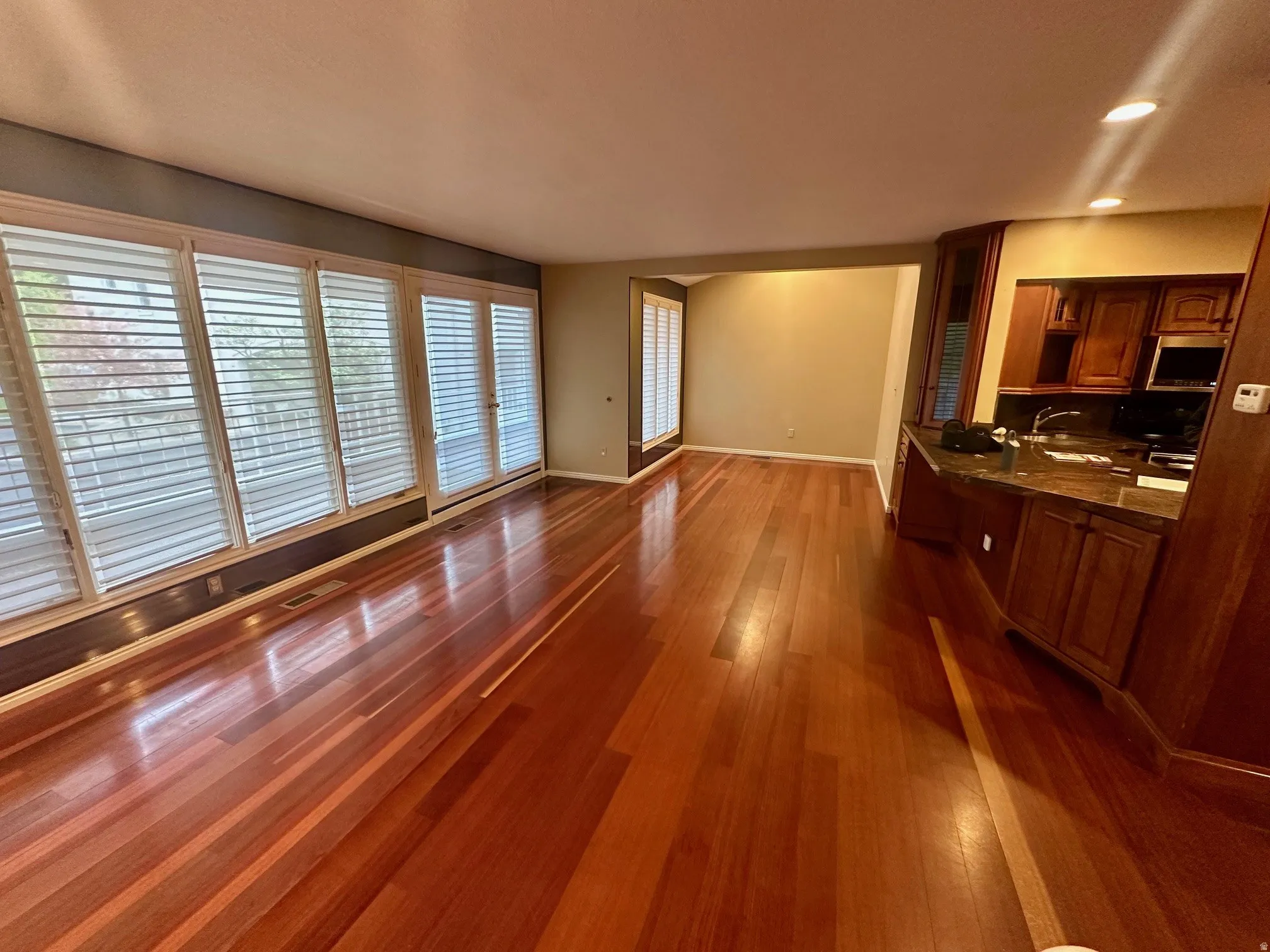 Expansive living area featuring rich wood-finish flooring