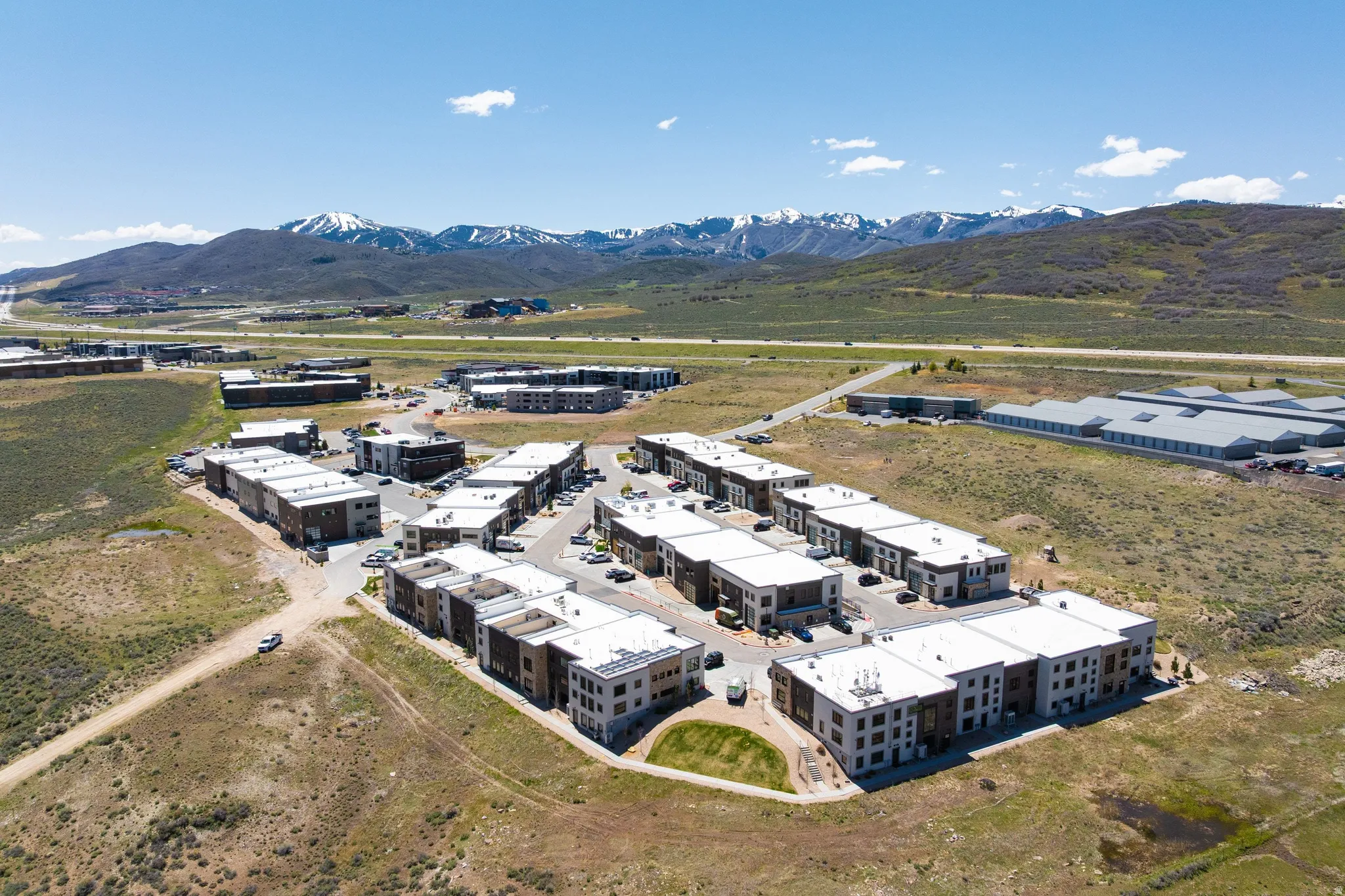 Aerial perspective showcasing a modern residential community with snow-capped mountains in the background