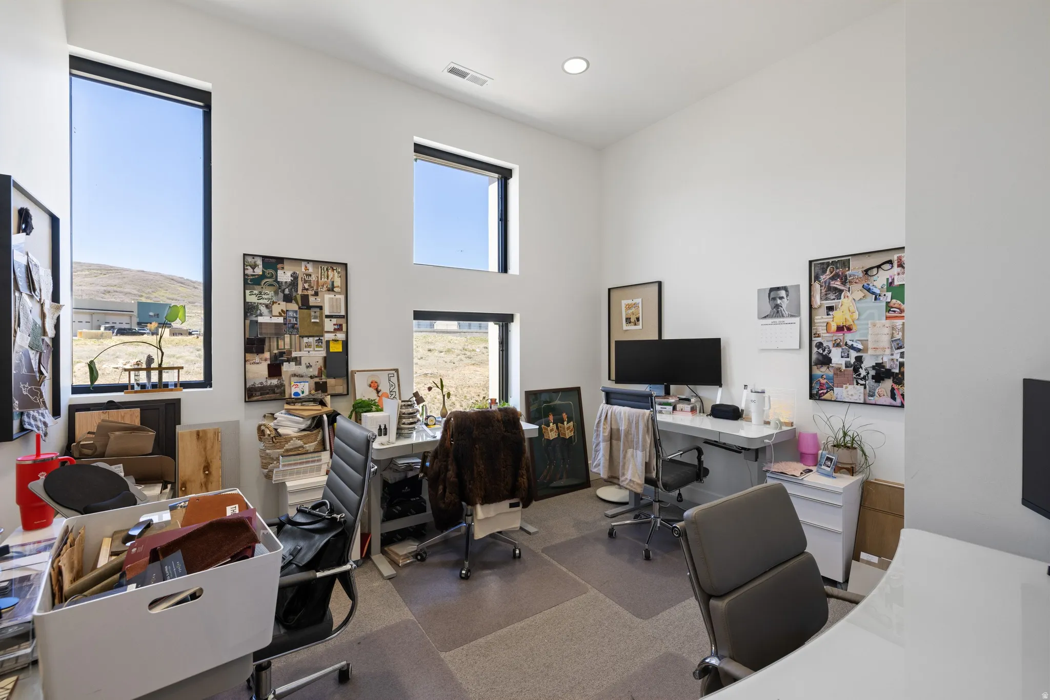 Contemporary interior space featuring high ceilings and multiple large windows