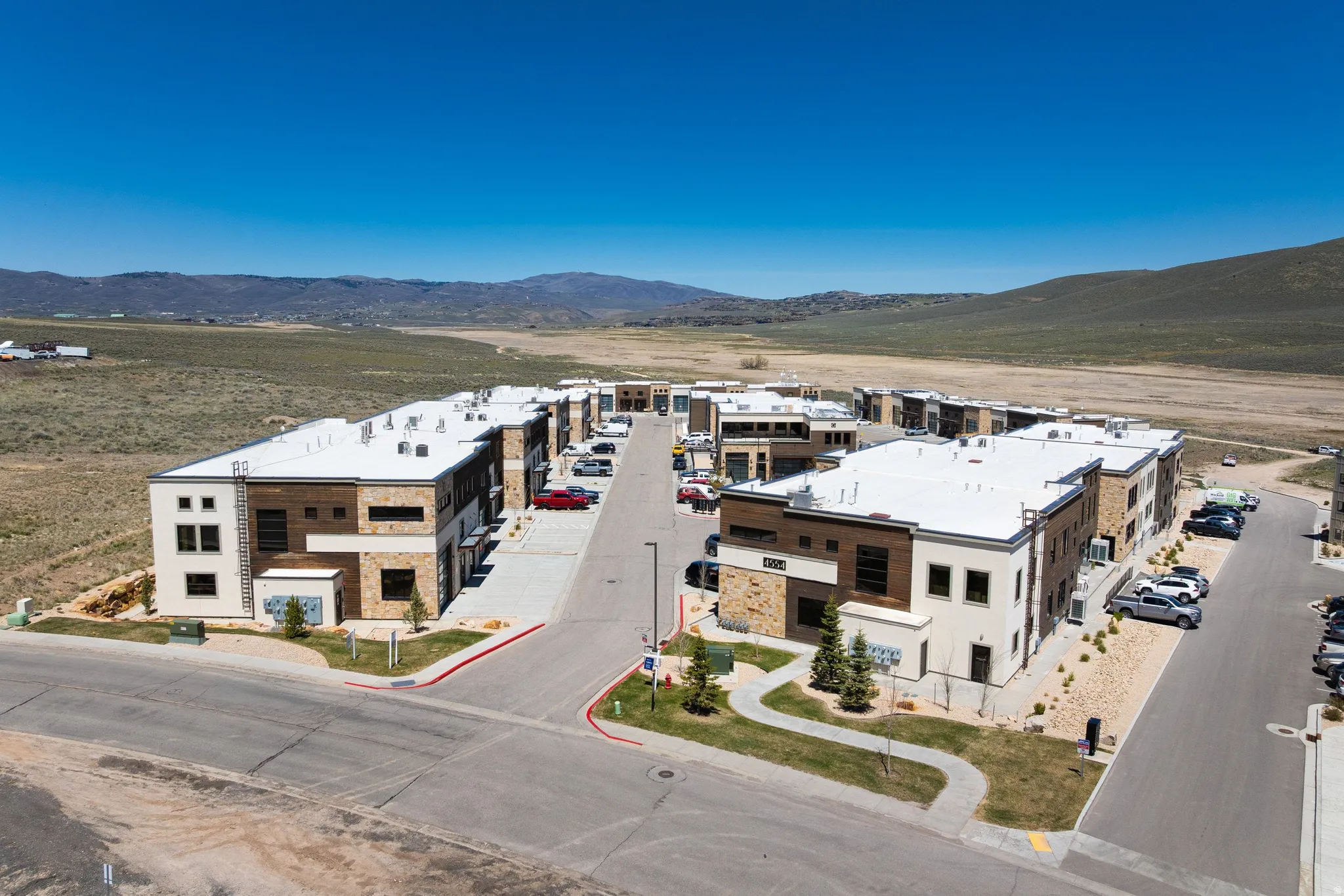 Modern multi-unit structures featuring stone and wood-finish paneling facades