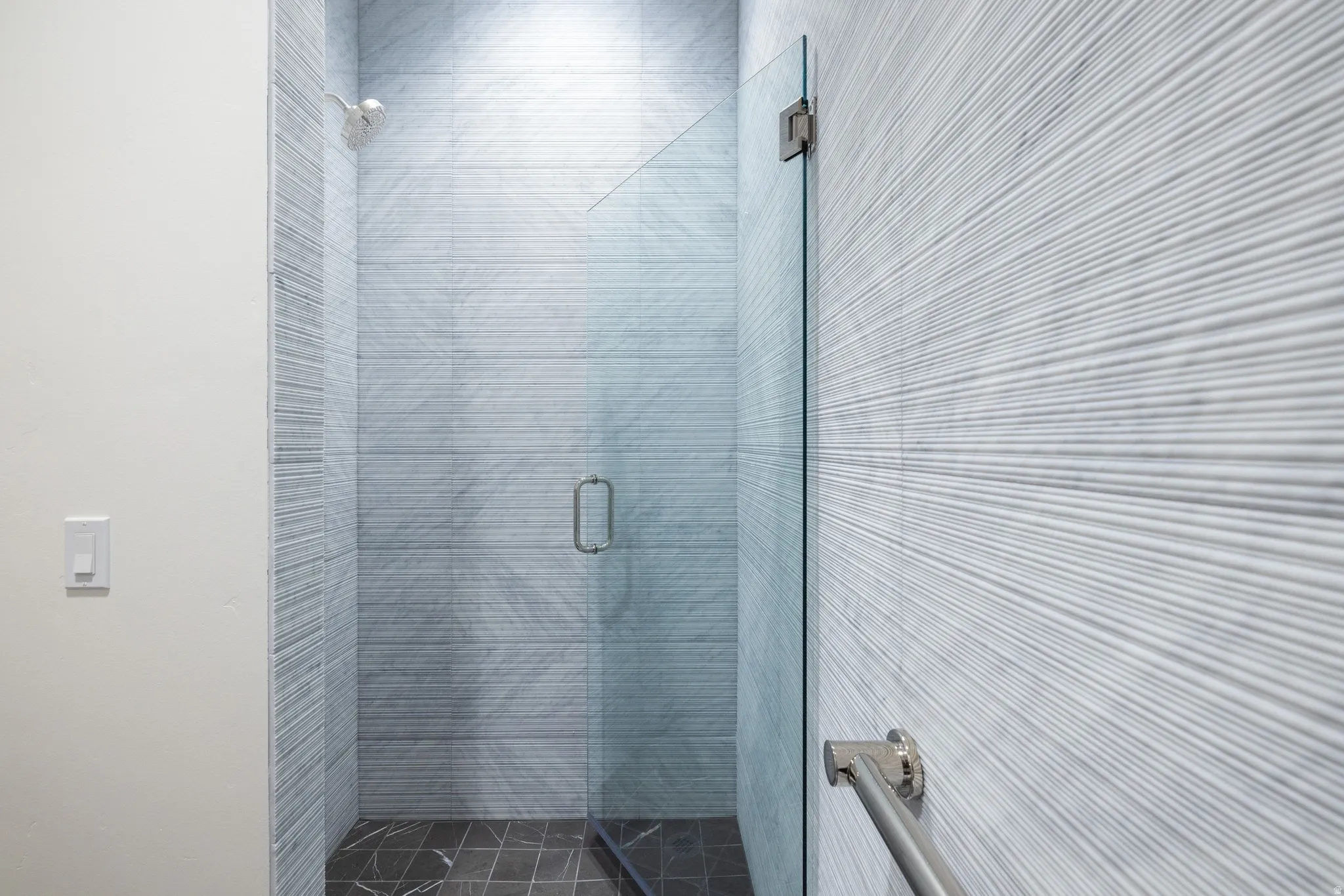 Modern walk-in shower with a frameless glass door and polished chrome hardware