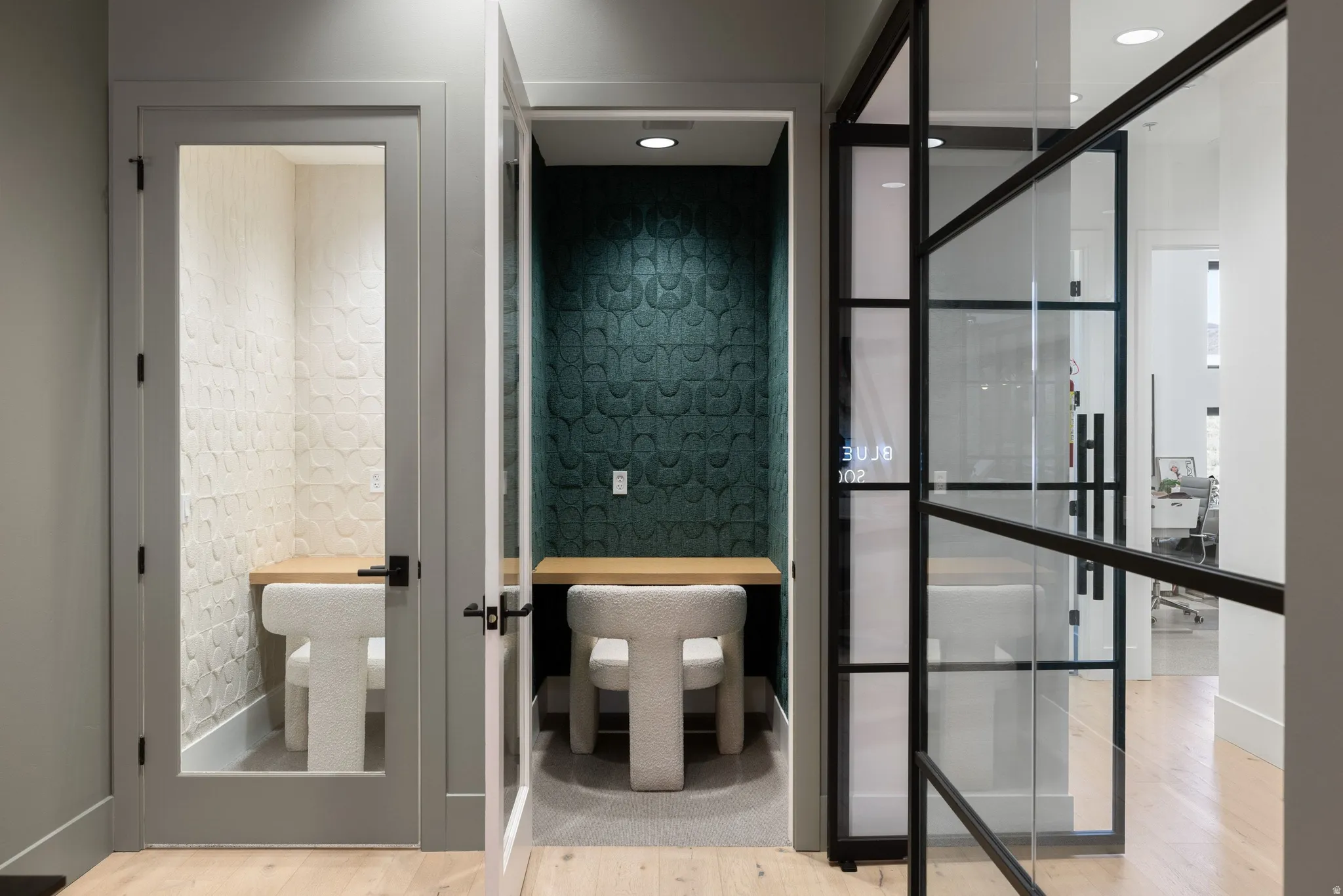 Two dedicated work nooks with built-in wooden desks, recessed lighting, and sound-dampening wall panels