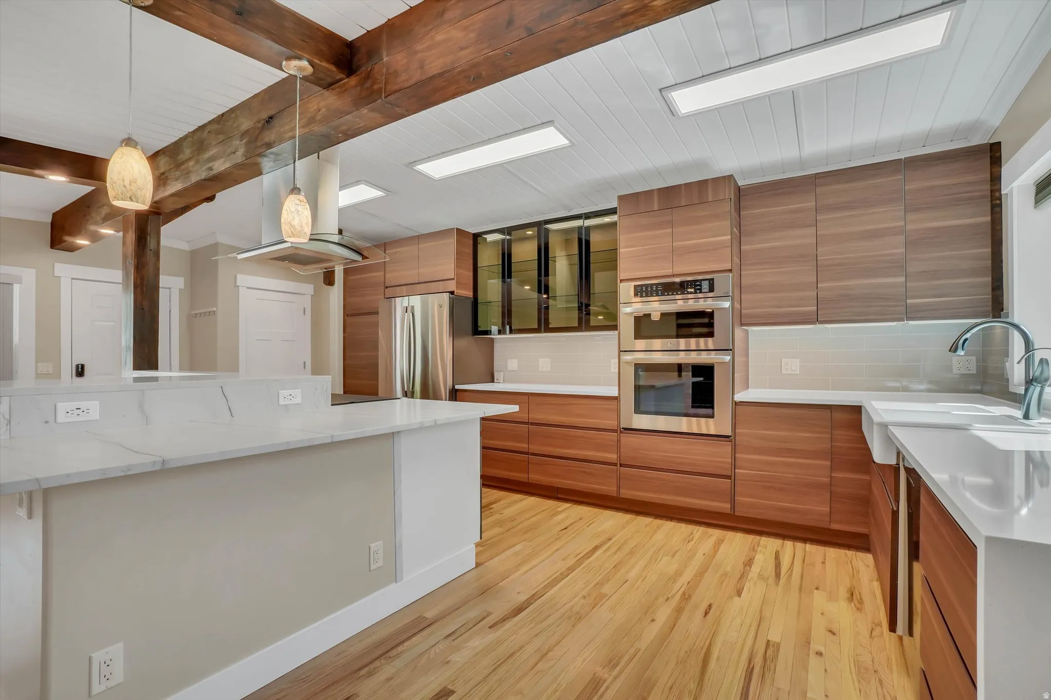 Kitchen featuring natural wood-finish flooring and exposed wooden beams