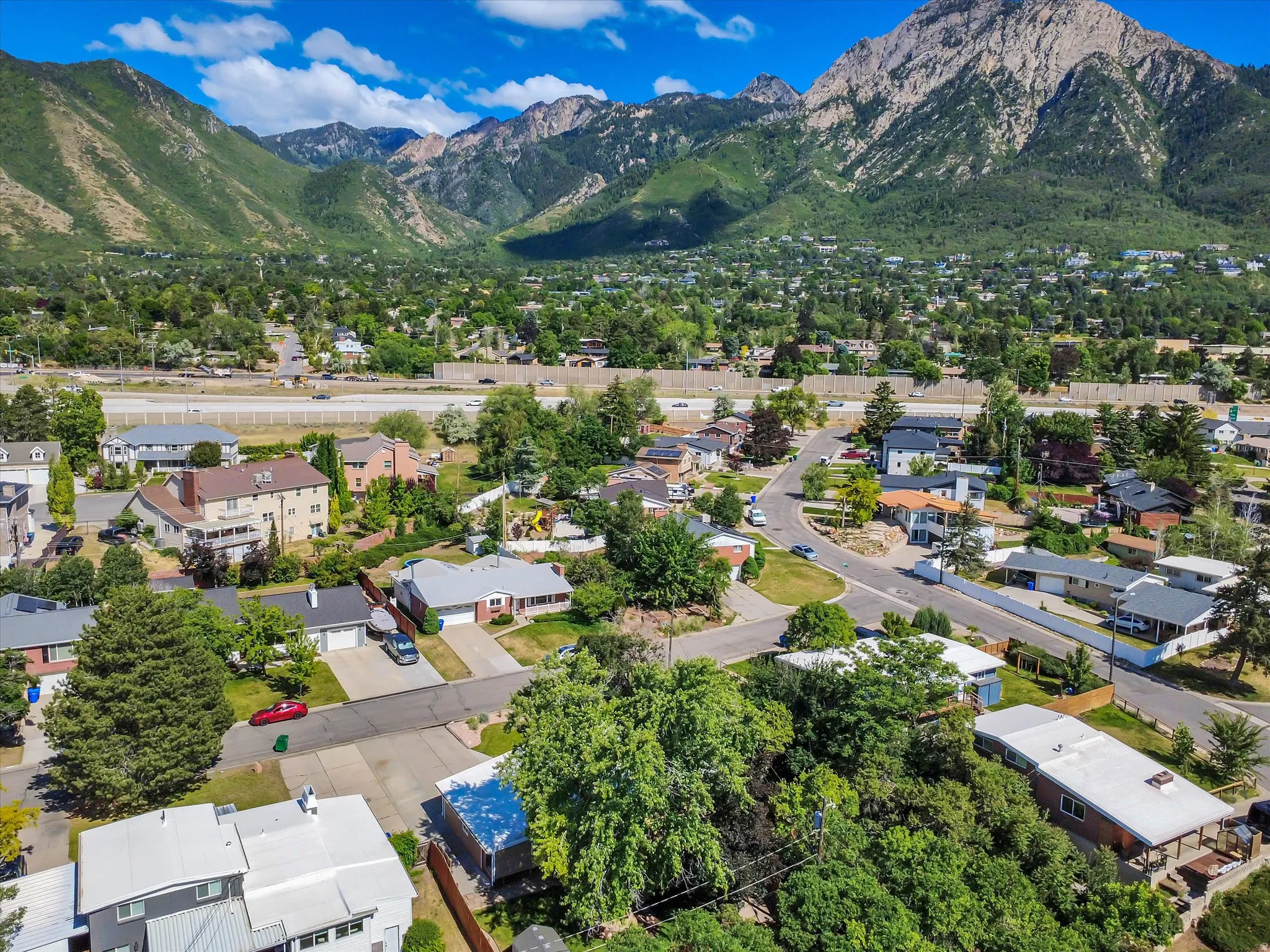 Aerial overview of a residential neighborhood with mountainous terrain in the background
